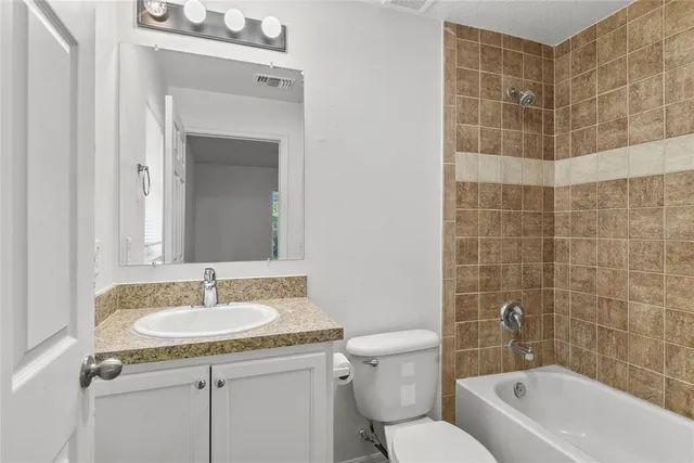 a bathroom with a sink toilet a mirror and bathtub