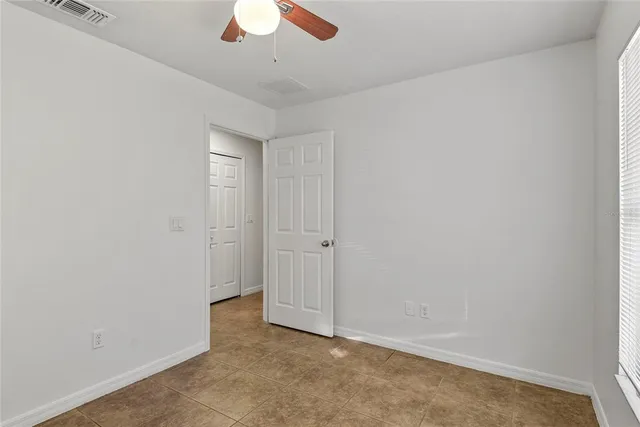 an empty room with a empty space and a ceiling fan