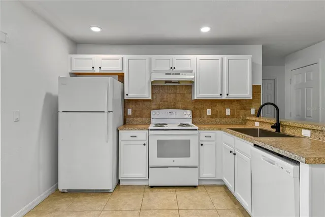a kitchen with cabinets appliances a sink and a counter top space