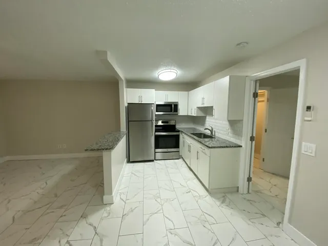 a kitchen with a refrigerator sink and cabinets