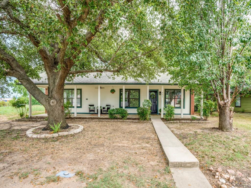 731 East Jacob Street Pilot Point, TX 76258 - Photo 1 of 1 a front view of a house with a tree and wooden fence
