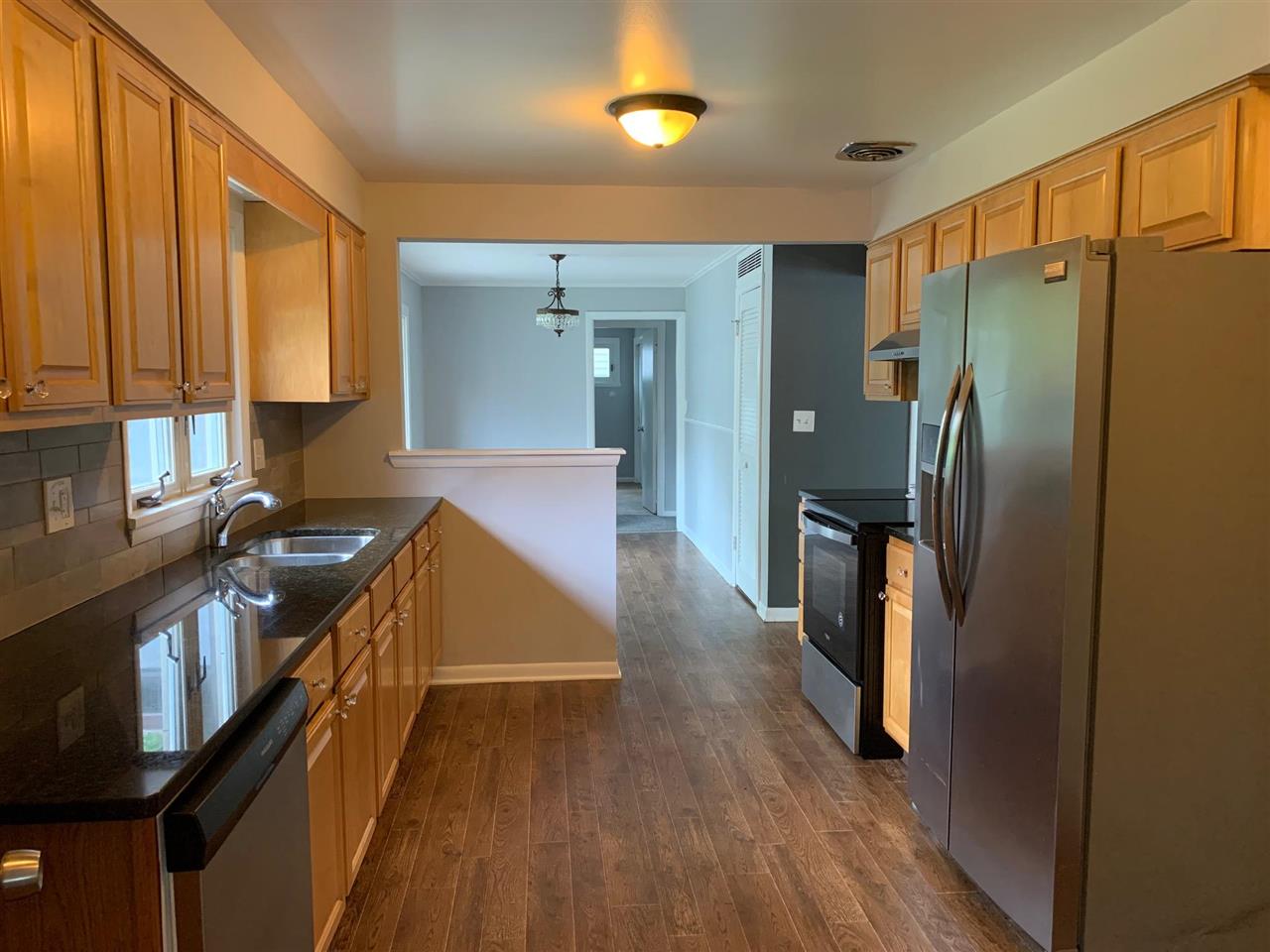 4119 Highcrest Road Rockford, IL 61107 - Photo 5 of 19 a kitchen with stainless steel appliances granite countertop a refrigerator a stove and a sink with wooden floor