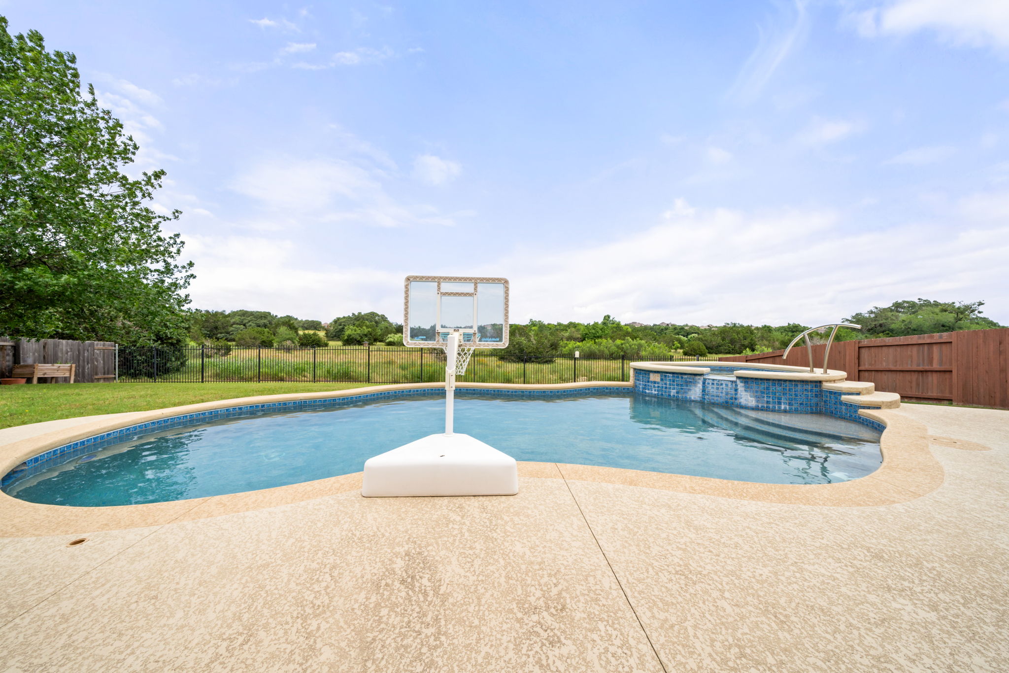 1581 Grassy Field Road Austin, TX 78737 - Photo 33 of 37 An inviting backyard swimming pool features integrated spa seating and scenic greenbelt views.