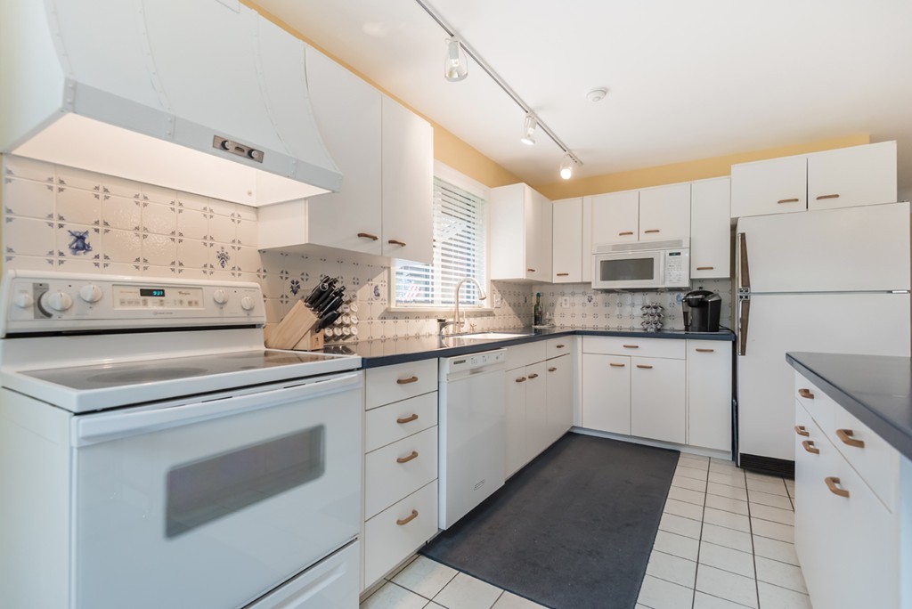 10 Regis Road Andover, MA 01810 - Photo 4 of 30 a kitchen with granite countertop white cabinets and white appliances