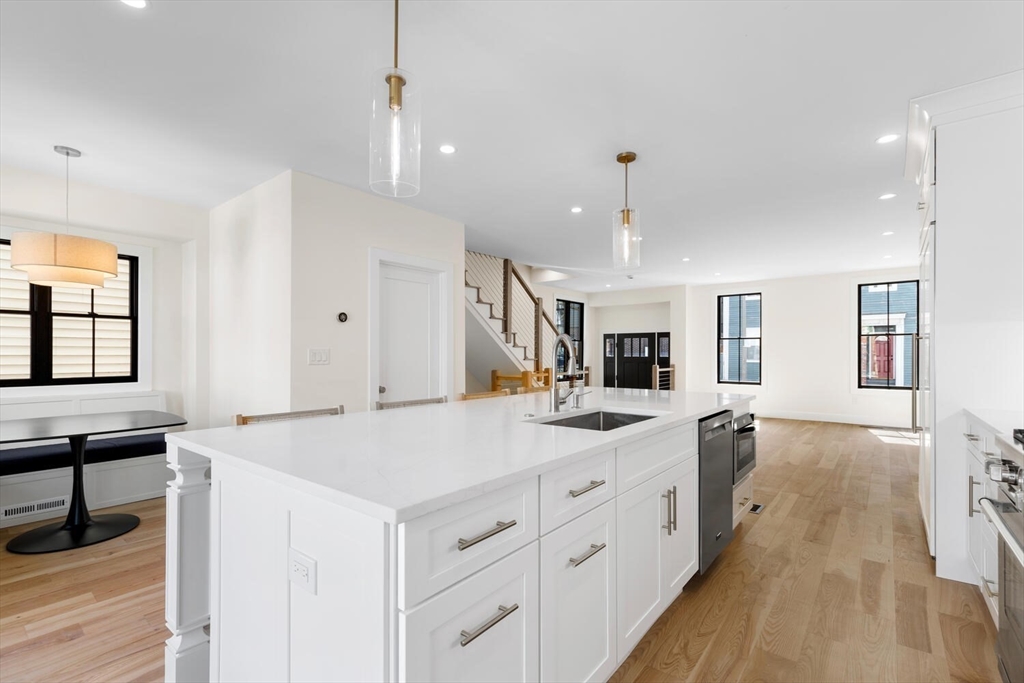 300 West 3rd Street, Unit 300 Boston, MA 02127 - Photo 6 of 23 a large kitchen with kitchen island a stove a sink a center island and wooden floor