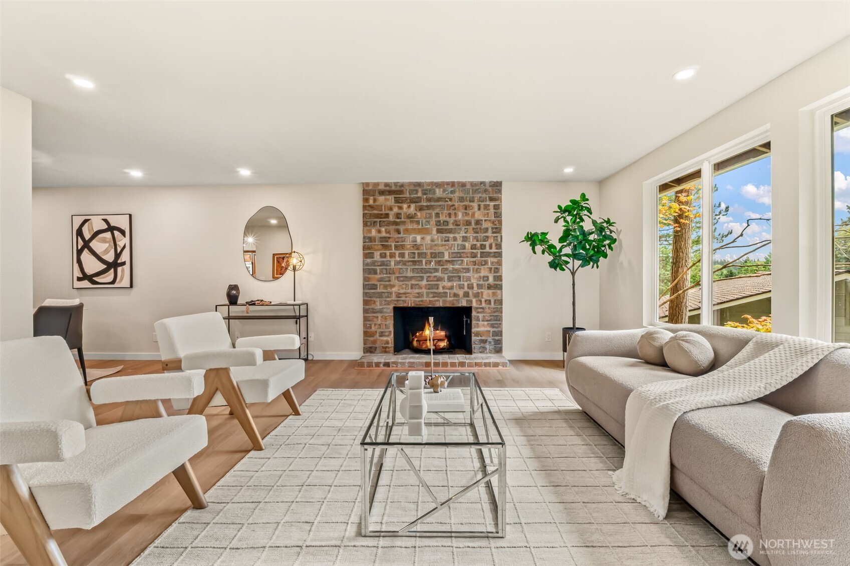 a living room with furniture a fireplace and a large window