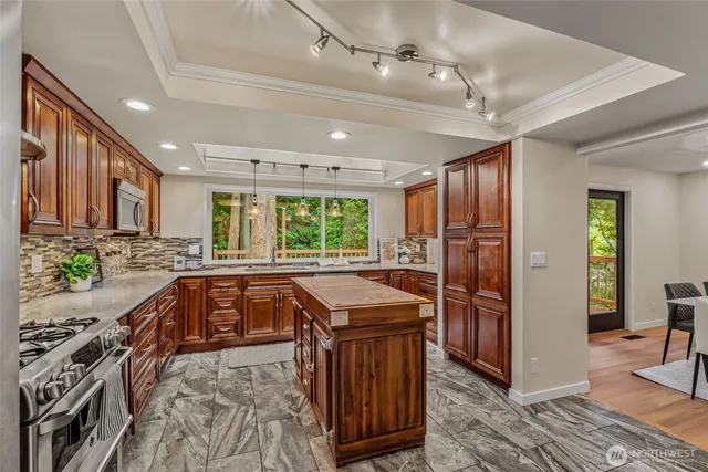 a kitchen with stainless steel appliances granite countertop a sink stove and refrigerator