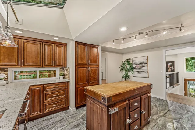 a kitchen that has a kitchen island wooden cabinets and refrigerator