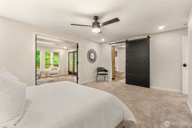 a large bed sitting in a spacious bedroom next to a window and a chandelier