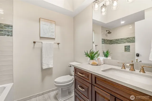 a bathroom with a granite countertop sink a toilet and shower