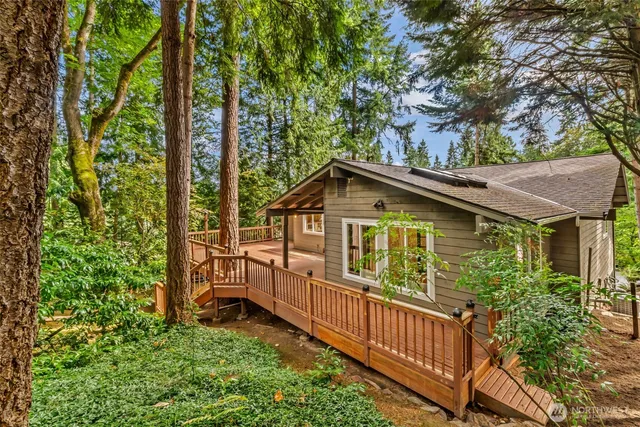 a view of a house with large windows and wooden fence