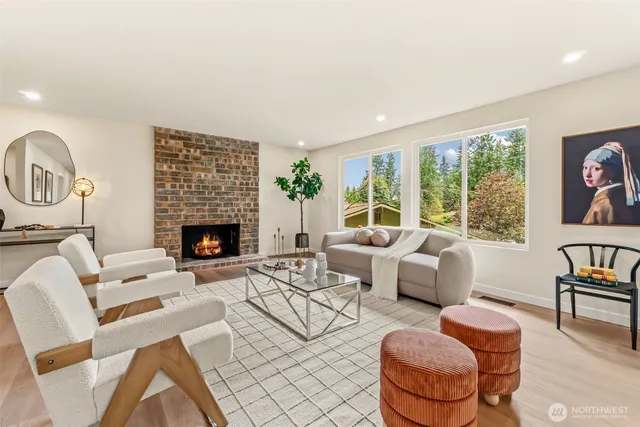 a living room with fireplace furniture and a large window