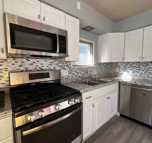 1035 Anderson Road Pittsburgh, PA 15209 - Photo 12 of 41 a kitchen with stainless steel appliances a stove a microwave a sink and cabinets