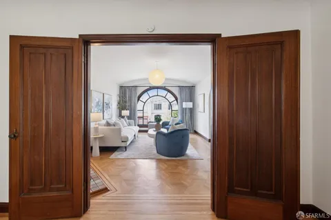 a view of a hallway with wooden floor and a mirror