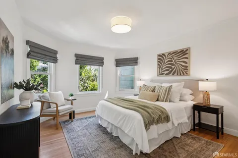 a bedroom with a bed and painting on the wall