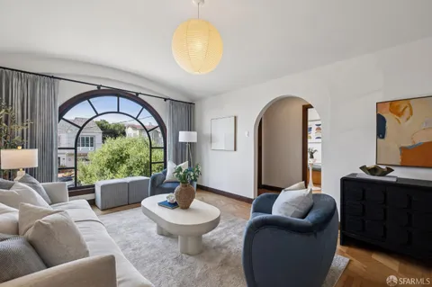 a living room with furniture a chandelier and a window