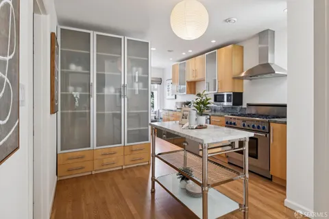 a view of a kitchen area with furniture and wooden floor