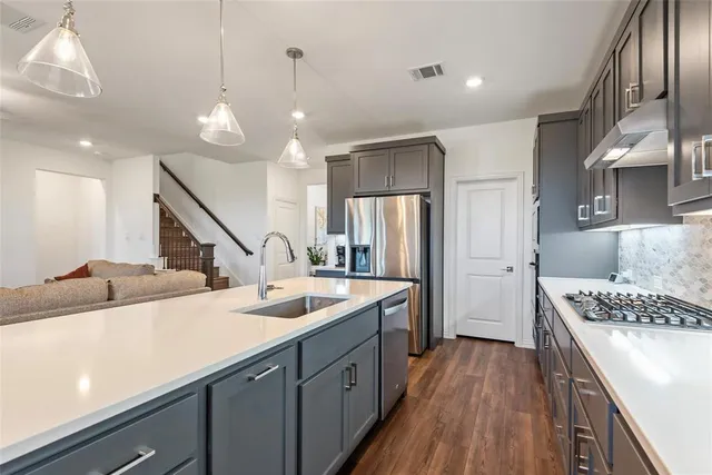 a kitchen with stainless steel appliances kitchen island a refrigerator and a stove top oven