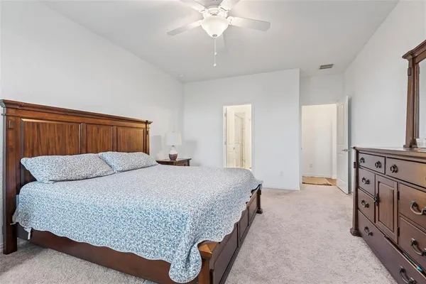 a bedroom with a bed and a mirror on dresser
