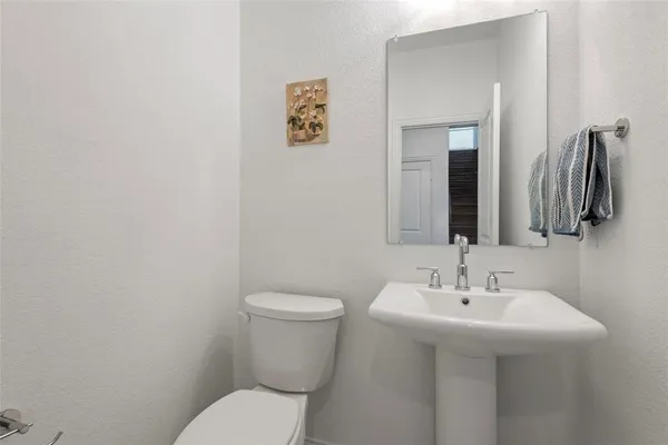 a bathroom with a sink mirror and toilet