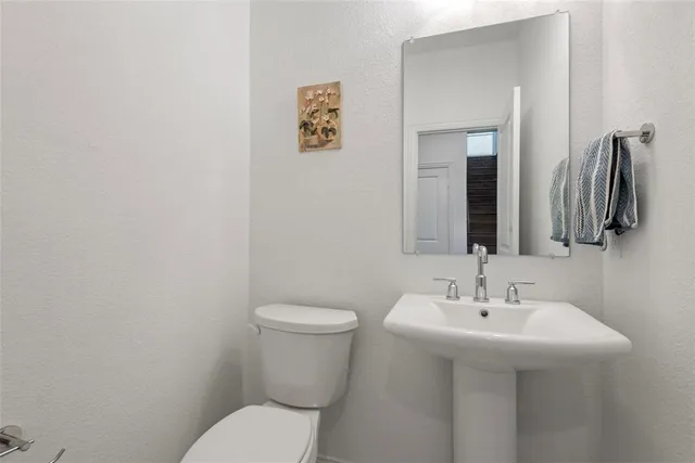 a bathroom with a sink mirror and toilet