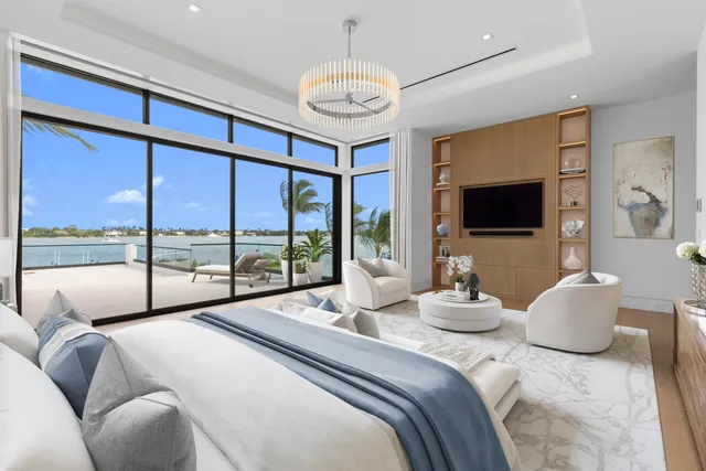 a bedroom with a large bed and a flat tv screen on dresser