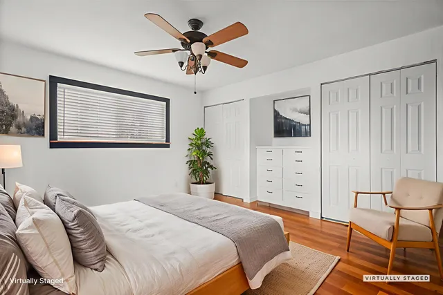 a bedroom with a bed a chandelier and a window