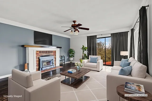 a living room with furniture fireplace and a large window