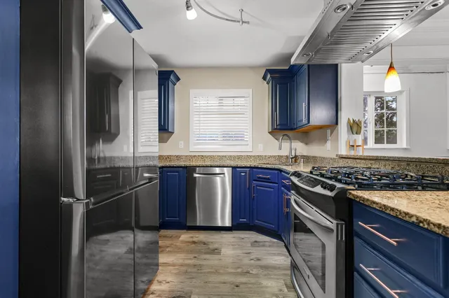 a kitchen with granite countertop stainless steel appliances and wooden cabinets
