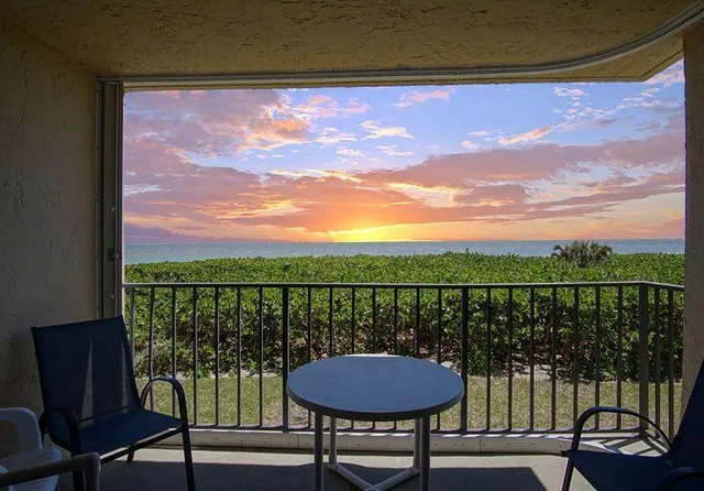 a view of a balcony with a floor to ceiling window and wooden floor