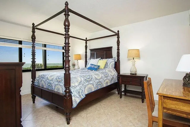 a bedroom with a bed and a flat tv screen on the dresser