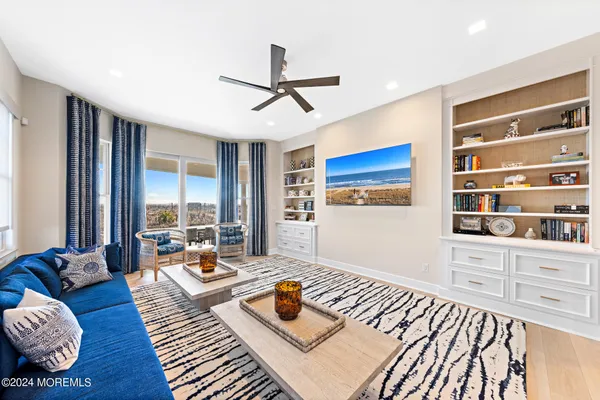 a view of a hallway with wooden floor and a living room