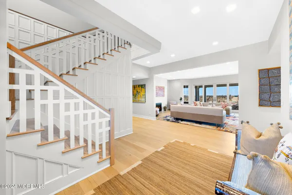 a view of staircase with lots of frames on wall and a dining table
