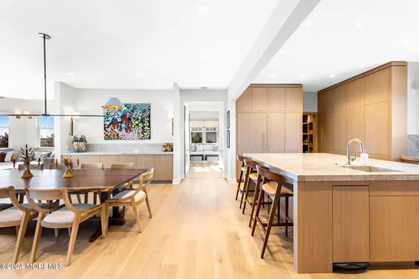 a view of kitchen island a sink wooden floor and living room view