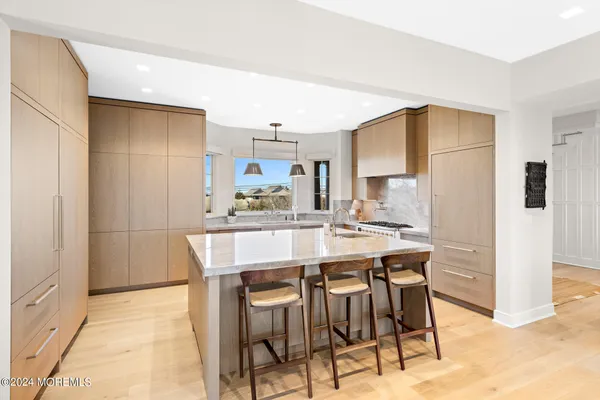 a kitchen with stainless steel appliances kitchen island granite countertop a kitchen island and chairs in it