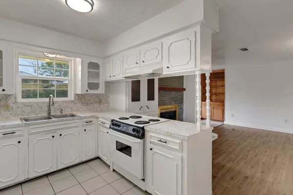 a kitchen with a stove sink and cabinets