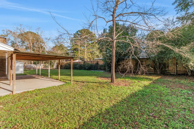 a view of a house with backyard and a tree