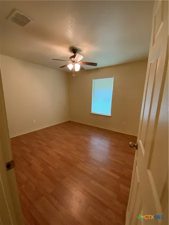 wooden floor in an empty room with a window