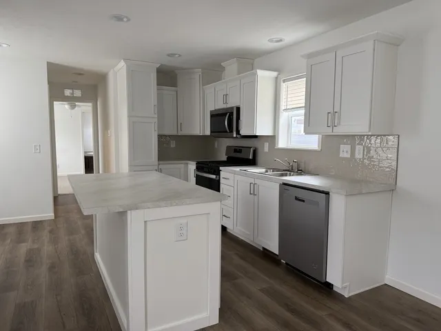 a kitchen with a sink a stove and cabinets