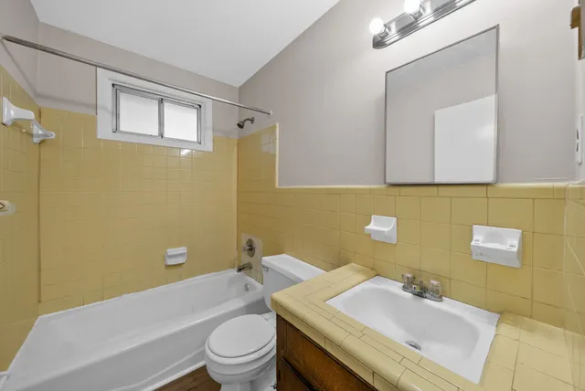 an empty room with wooden floor and ceiling fan