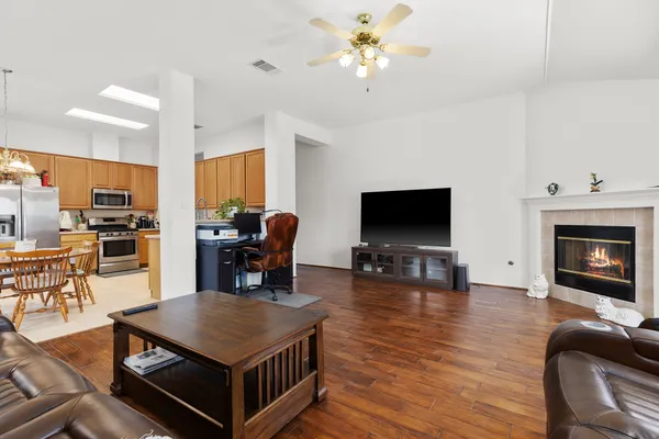 a living room with furniture a flat screen tv and kitchen view