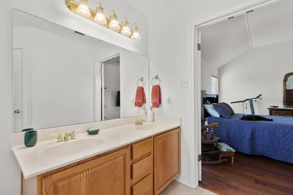 a en suite bathroom with a double vanity sink and a mirror
