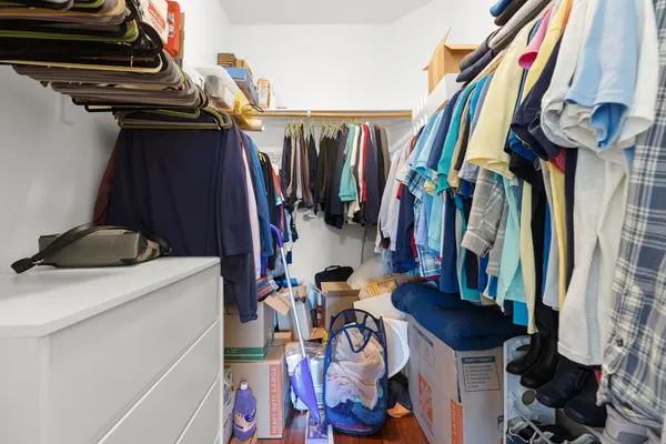 a view of walk in closet with clothes and shoes