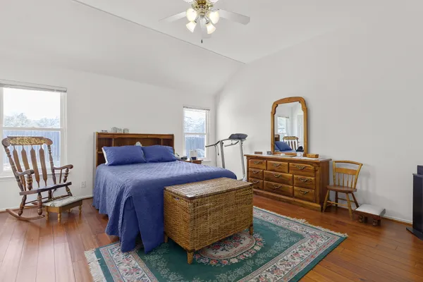 a bedroom with a bed a chandelier and a dresser