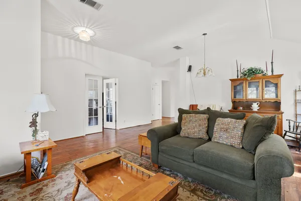 a living room with furniture a chandelier and a rug