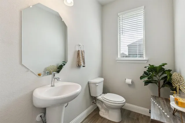 a bathroom with a sink toilet and a mirror