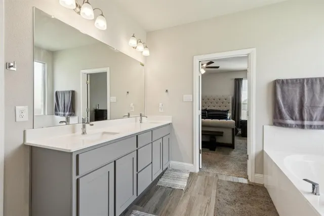 a en suite bathroom with a double vanity sink a mirror and shower