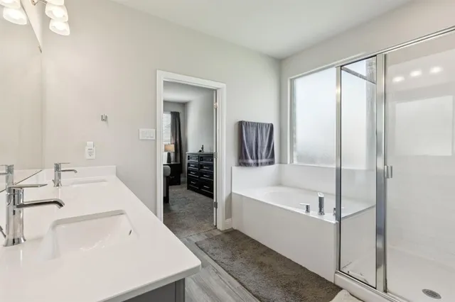 a en suite bathroom with a tub sink and mirror