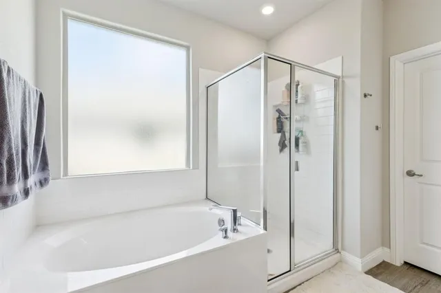 a white bath tub sitting next to a shower