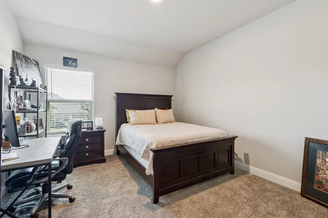 a bedroom with a bed and a flat tv screen on the dresser
